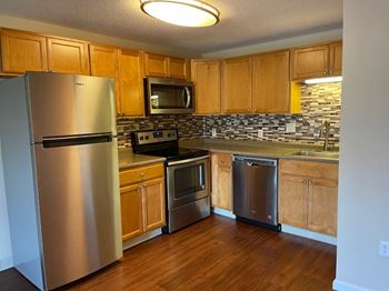 A kitchen with stainless steel appliances and wooden cabinets
